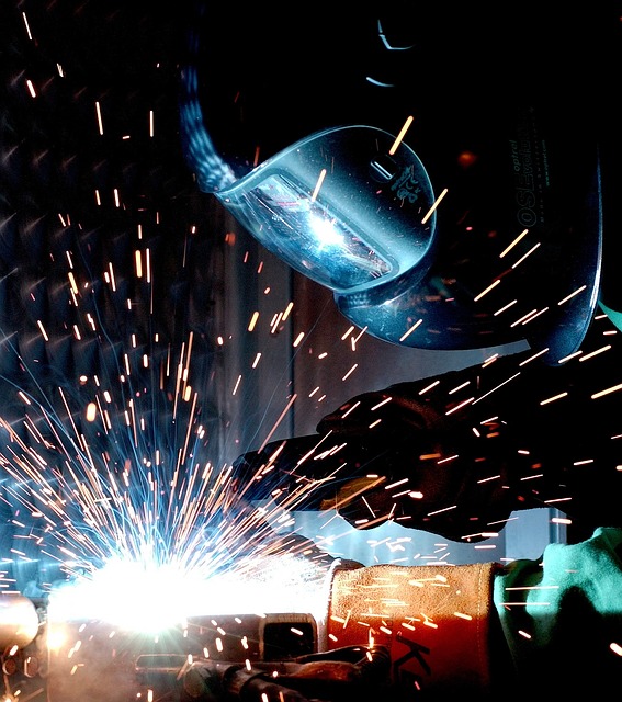 Photo of someone welding with many sparks.